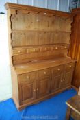 A modern pine dresser with five small drawers and two cupboards, 58 1/2" wide x 17" deep x 74" high.
