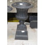 An elegant cast iron planter/urn having fluted and reeded design and an associated matching but