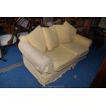 Two seater yellow covered settee with blue cushions.