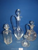 Three various decanters to include one with painted flowers and leaves, a large footed decanter,