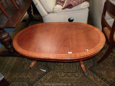 A golden Mahogany double pedestal Coffee Table having a crossbanded top,
