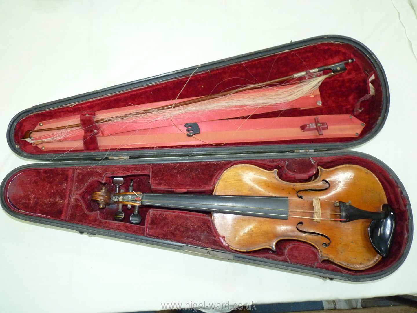 An antique violin having a well-carved scroll and nicely figured body including the back,