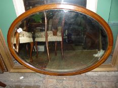 An oval bevelled edge wall mirror.