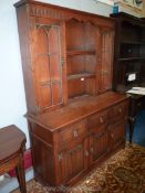 An Old Charm/Priory Oak style contemporary Dresser having a flight of central shelves flanked by