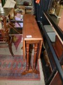 A Mahogany Sutherland Table standing on turned legs, 24'' x 6 1/4'' extending to 23 1/4''.