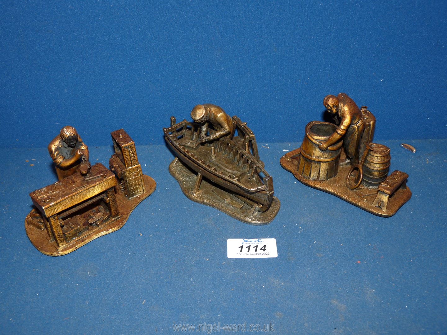 Three Evergreen metal figures; cobbler, cooper, boat builder.