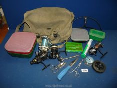 A canvas fishing bag containing a quantity of fishing reels, one reel 'Garcia 600A', scissors,