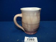 A small Eweny pottery jug in pale mottled pink, darker at the base and fading into a mauve,