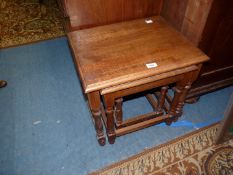 A Nest of three heavy Oak Occasional Tables standing on turned legs,