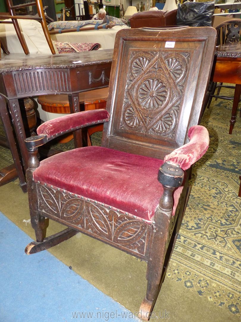 An unusual dark oak Rocking Chair having carved decoration and unusually with an underseat drawer