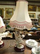 A continental porcelain table Lamp in the form of children on a swing, with tasselled lamp shade,