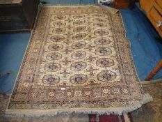 A beige ground, orange and navy blue bordered, patterned and fringed Rug with octagonal motif,