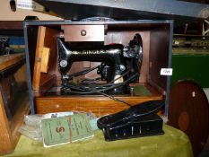 A Singer electric sewing machine in a case with accessories, no. EA353843.