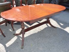 A contemporary Mahogany finished cross-banded with Yew wood double pedestal Dining Table on three