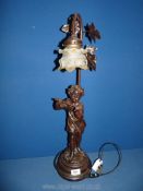 A bronzed effect Table lamp with boy playing flute, with glass shade, 26" tall.