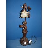 A bronzed effect Table lamp with boy playing flute, with glass shade, 26" tall.