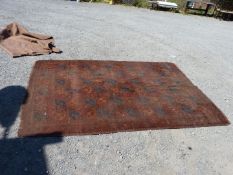 A red/rust ground bordered, patterned Carpet, 116" x 78".