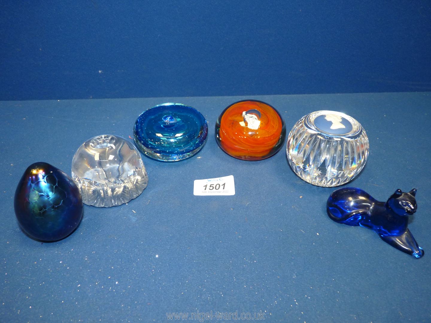 Six glass paperweights to include blue cat, orange swirl paperweight, Lakeland egg,