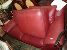 A maroon leather upholstered three seater Settee and pouffee/stool