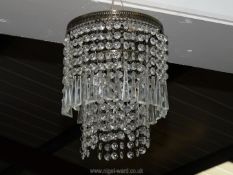 A two tier brass and drop crystal light fitting, 8" diameter.