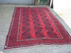 A large bordered, patterned and fringed red ground Carpet with octagonal shaped motifs,114'' x 85''.