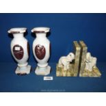 A pair of Italian mottled alabaster bookends surmounted by cream elephants,