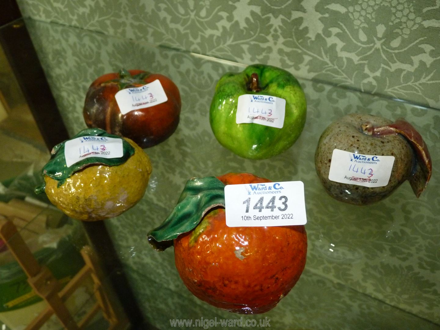 Five ceramic fruits including lemon and mango