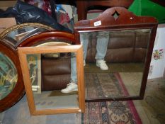 Two mirrors including a larger one with dark wood frame with diamond cut out to top.