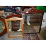 Two mirrors including a larger one with dark wood frame with diamond cut out to top.