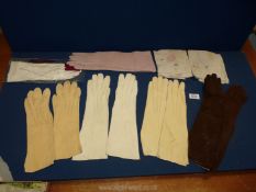 A quantity of gloves to include; four pairs of cream 3/4 length, a pair of long brown suede,