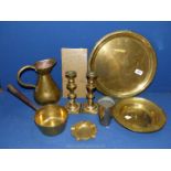 A quantity of brass including trays, jug , candlesticks with pushers, beaker etc.