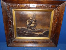 A carved wooden framed Oil on canvas depicting a sailing vessel on high seas in brown tones,