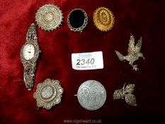 A small quantity of metal brooches including a bird, leaves, a coin, etc.