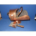 A copper coal scuttle and shovel with wooden handle.