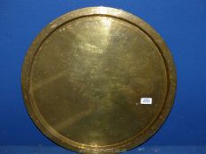 A large brass charger with engraved Moorish lettering and floral motifs, 21'' diameter.