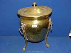 A brass lidded urn on three legs with paw feet and three handles, lid very bent and dented,