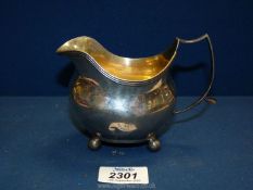 A Silver cream Jug standing on four ball feet, date code for possibly 1789, some dents, 130g,