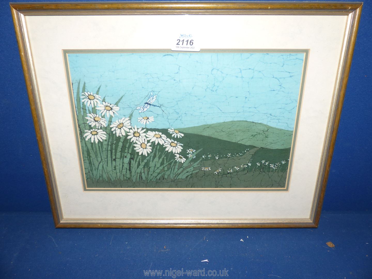 A framed and mounted Batik painting by the artist Buffy Robinson titled 'Daises and Dragonfly 1991'.