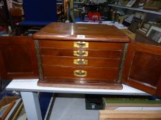 A large Mahogany case canteen (incomplete) of cutlery with double doors and pull out drawers having