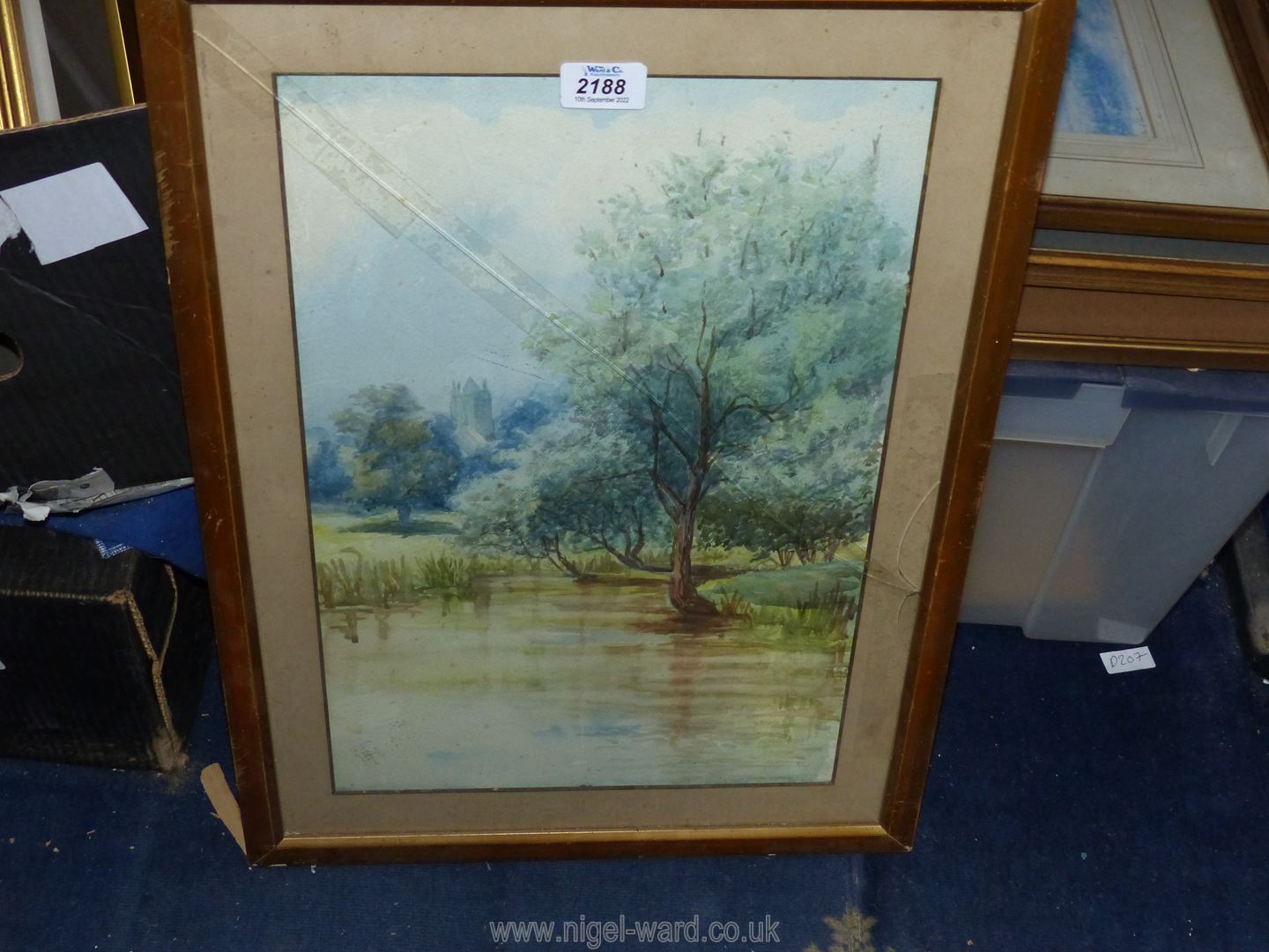 A framed and mounted watercolour of a River landscape and a church in the distance, glass a/f.