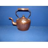 An oval shaped copper kettle.