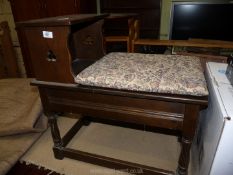 A dark wood telephone table with compartment and cushion.