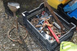 An old brass upstanding water sprinkler and a tray of tools.