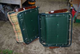 Two garden loungers in tartan fabric, metal frames and wooden arm rests.