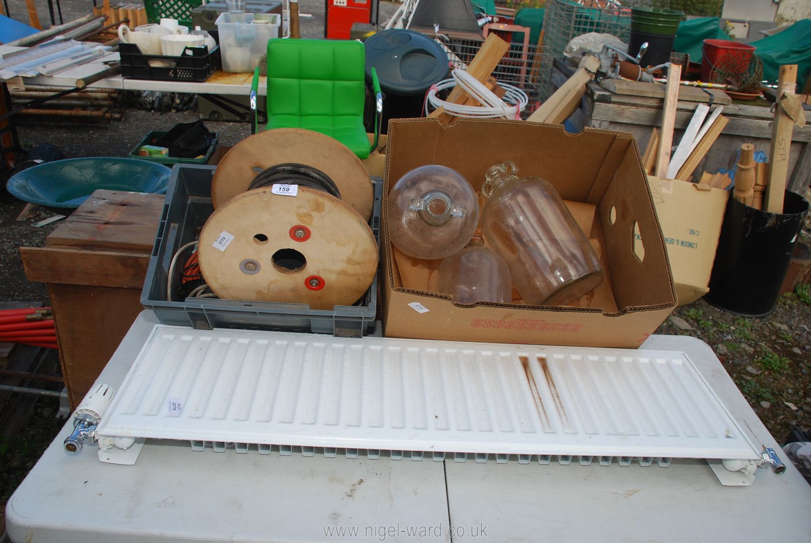 A radiator, box of electric cable on reel, 3 Demi-Johns etc.