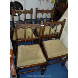 Four Ercol dining chairs with carved detail and green upholstered slot in seats.