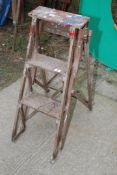 A wooden three rung step ladder.