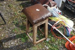 An old leather seated stool with pine legs.