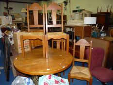 A circular dining table on a metal base with 4 chairs.