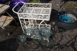 A wrought iron trolley and a plant stand.